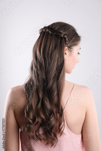 Woman with braided hair on light background, back view