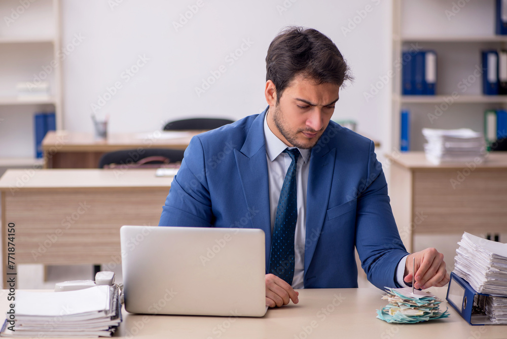 Young male employee working in the office - obrazy, fototapety, plakaty 