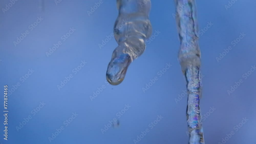 Close up and super slow motion of dripping droplets from icicle melting in sunny day against clear blue sky. Close up and super slow motion of dripping droplets from icicle melting in sunny day against clear blue sky.