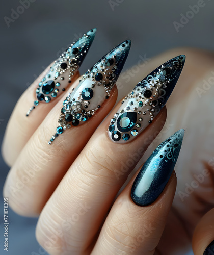 Close up of womans hand adorned with long, rhinestonestudded nails