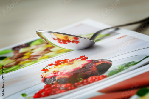 Reflection from a cookbook in a metal spoon.