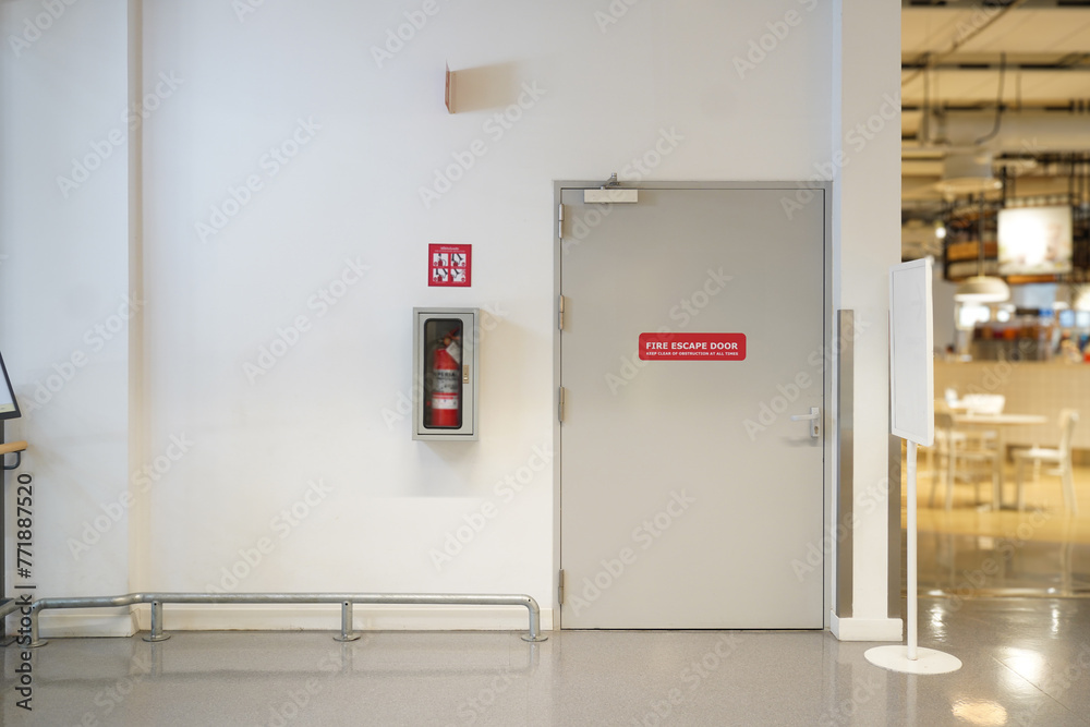 Fire extinguishers and fire escape door within the department store Fire extinguishers and fire escape door within the department store
