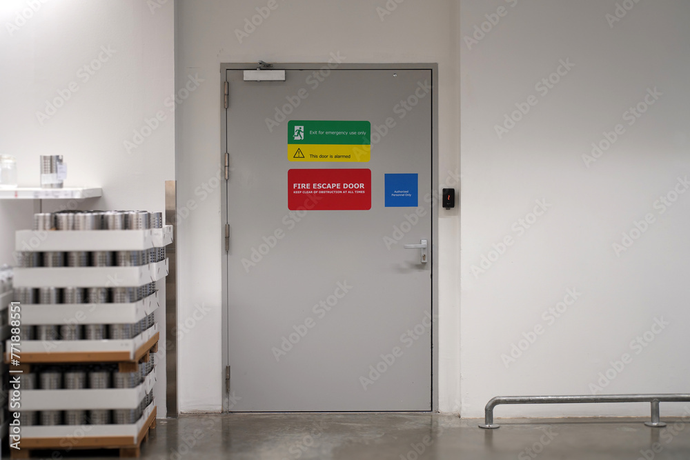 Fire extinguishers and fire escape door in building Fire extinguishers and fire escape door in building