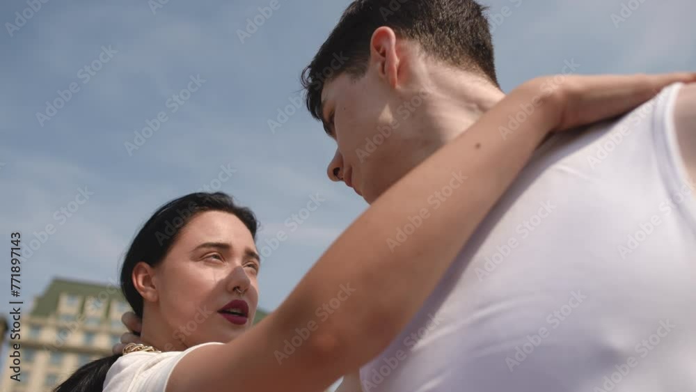 Slow motion. Close-up. A guy and a girl look at each other during a street dance, dancing on a summer day in a city square outdoors. A guy and a girl enjoy the street dance and each other. Low Angle Slow motion. Close-up. A guy and a girl look at each other during a street dance, dancing on a summer day in a city square outdoors. A guy and a girl enjoy the street dance and each other. Low Angle