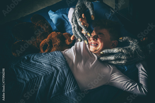 Φωτογραφία Terrified young boy in bed at night attacked by a scary monster