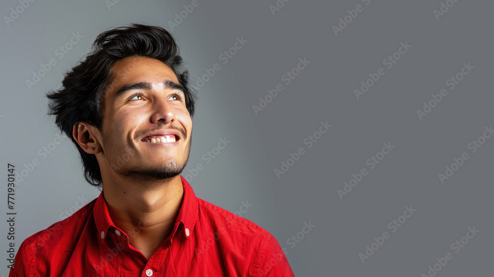 Side view candid of hispanic businessman in red shirt smiling isolated Side view candid of hispanic businessman in red shirt smiling isolated