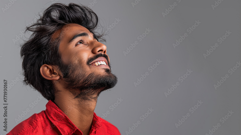 Side candid view of Indian businessman in red shirt smiling isolated Side candid view of Indian businessman in red shirt smiling isolated