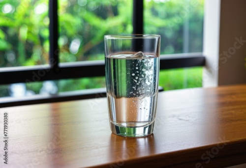 A crystal-clear glass of refreshing water resting gracefully atop a wooden table