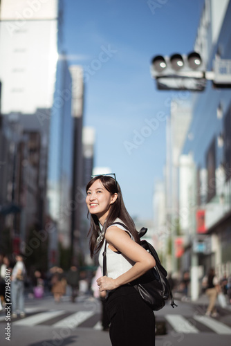 Tokyo vibes, A confident Japanese woman in her 30s, blending business, technology, and urban style while enjoying a leisurely walk.