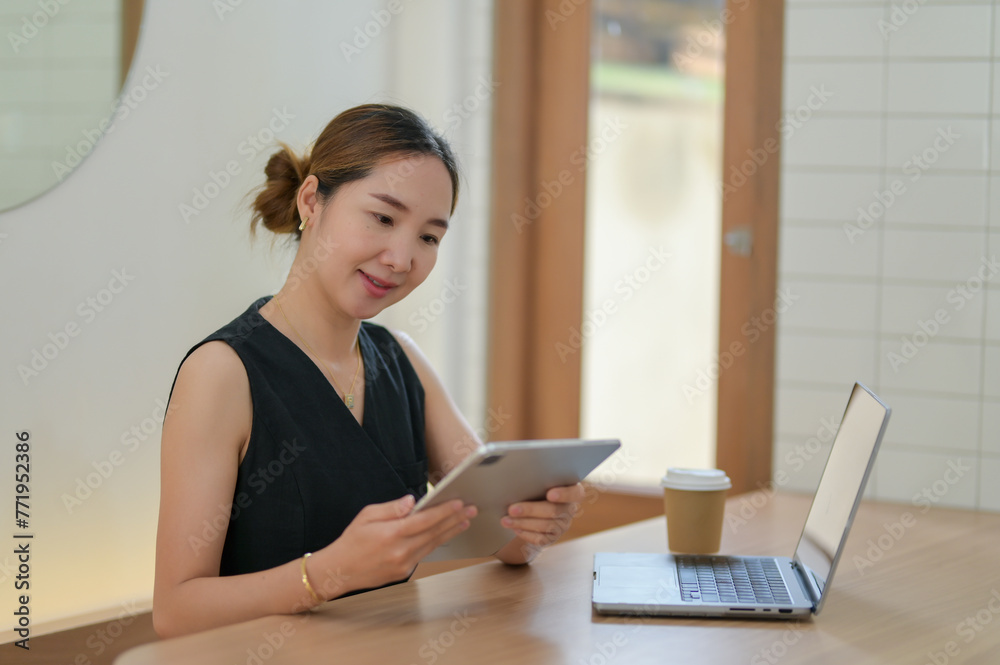 Businesswoman Multitasking with Tablet and Laptop Businesswoman Multitasking with Tablet and Laptop