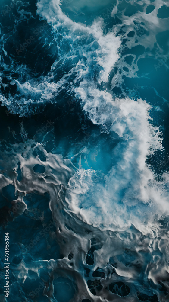 Churning ocean waves with white froth create a dramatic contrast against the deep blue water.