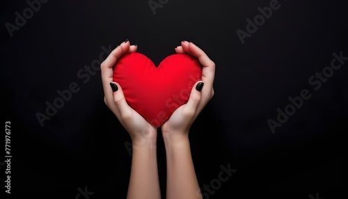woman makes her hand a heart shape covering a red heart