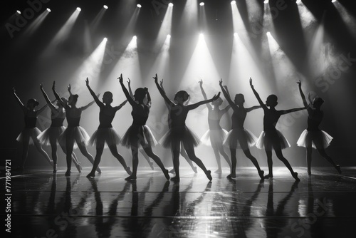 Dancers performing on stage with arms lifted in the air, showcasing a dynamic and energetic routine