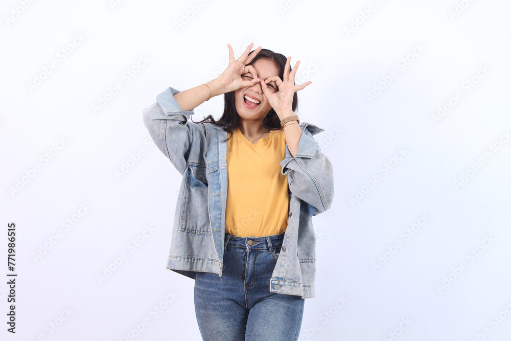 Happy young Asian woman shows ok sign with two hands on eye isolated white background Happy young Asian woman shows ok sign with two hands on eye isolated white background