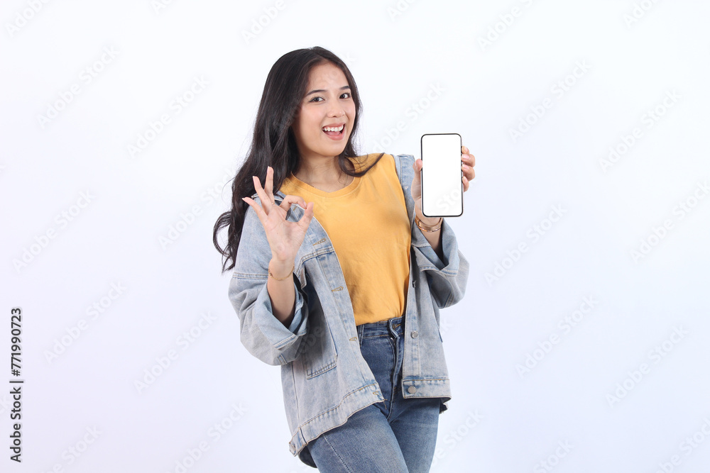 Happy young Asian woman feeling happiness and gesture showing mobile smartphone blank screen interface and ok sign on isolated white background. Happy young Asian woman feeling happiness and gesture showing mobile smartphone blank screen interface and ok sign on isolated white background.