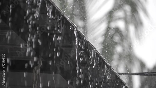 Slowmotion of rainwater falling from roof tiles.