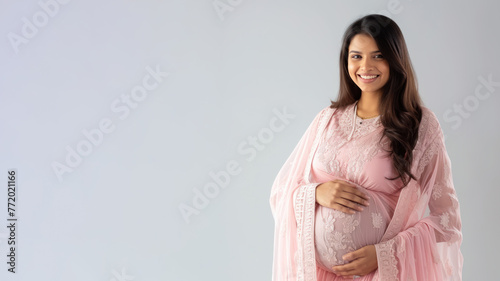 Indian pregnant woman with pregnancy belly, in soft pink clothes