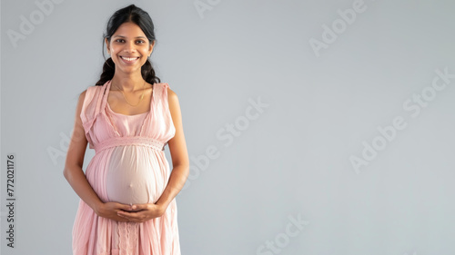 Indian pregnant woman with pregnancy belly, in soft pink clothes © pariketan