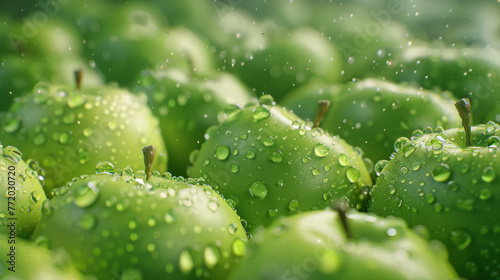 Glistening with water droplets, green apples fill the frame with freshness and vitality.