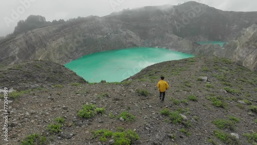 A man walks down the Kelimutu lake to see the three-colored crater