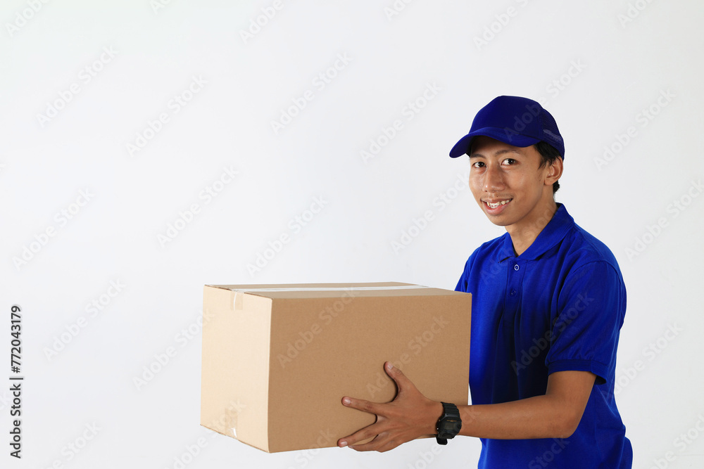 Delivery Man in Blue Uniform Send Package in Cardboard Box. Delivery Man in Blue Uniform Send Package in Cardboard Box.
