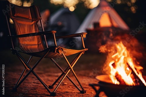 Camping Chair by the Fire: Capture the details of a camping chair with a person sitting by the fire, surrounded.