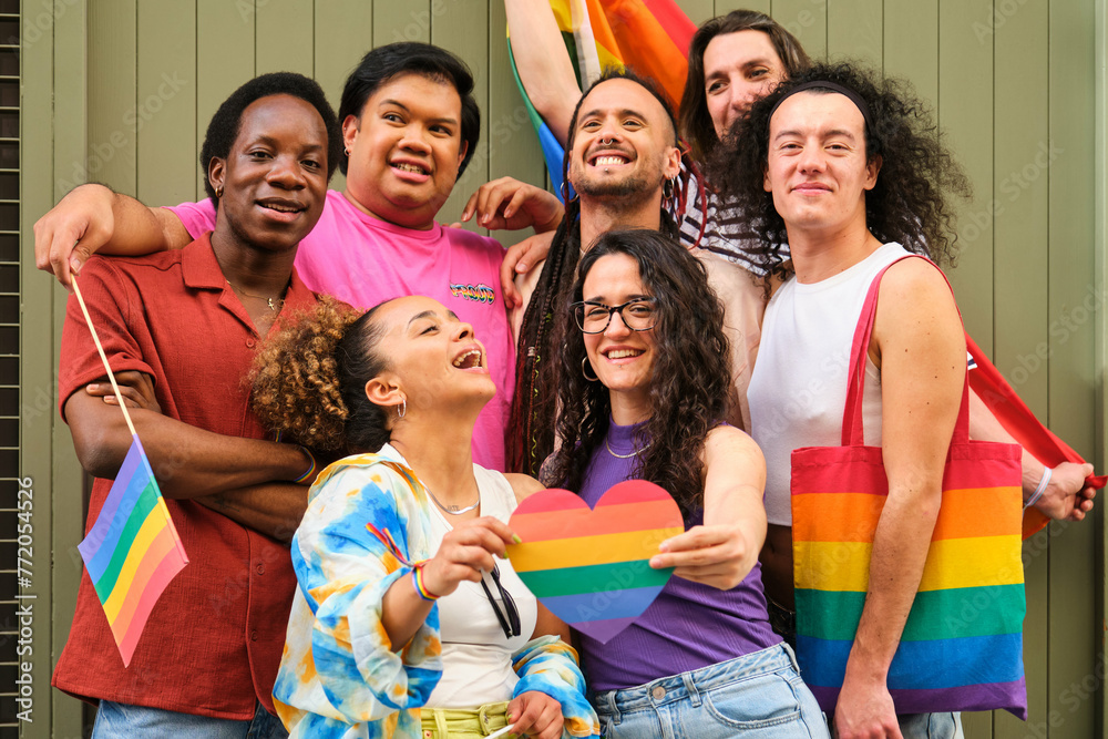 A group of people are holding rainbow flags and heart and laughing at Pride Day. Scene is happy and celebratory, as the group is likely participating in a pride event or gathering. A group of people are holding rainbow flags and heart and laughing at Pride Day. Scene is happy and celebratory, as the group is likely participating in a pride event or gathering.