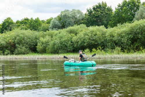 People float down a calm river in Europe in inflatable rubber boats.