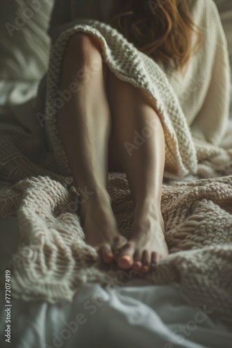 a woman's feet covered in a blanket with a sheet