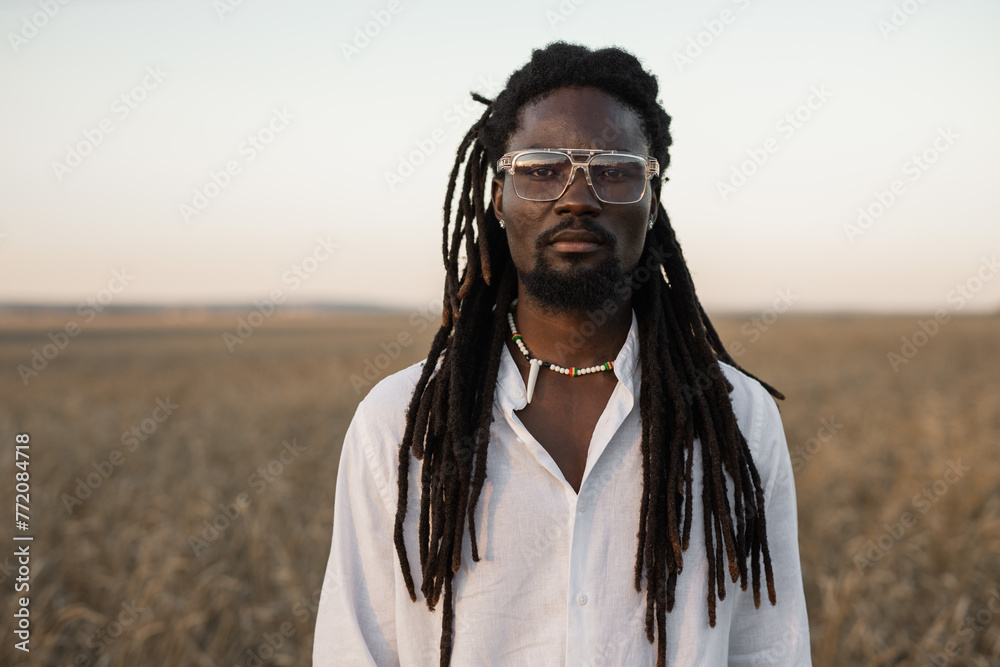 stylish african man in glasses in the field in summer stylish african man in glasses in the field in summer