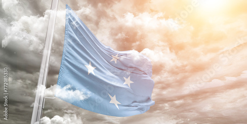 Micronesia, Federated States of Micronesia national flag cloth fabric waving on beautiful cloudy Background.