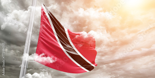 Trinidad and Tobago national flag cloth fabric waving on beautiful cloudy Background. photo