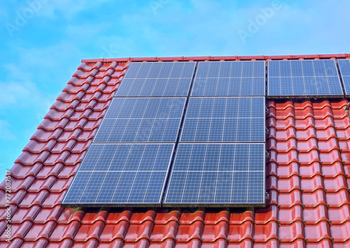 solar panels on a red tiled roof, blue sky
