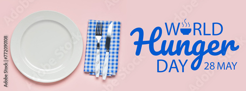 Empty plate, fork and knife on blue checkered napkin on pink background photo