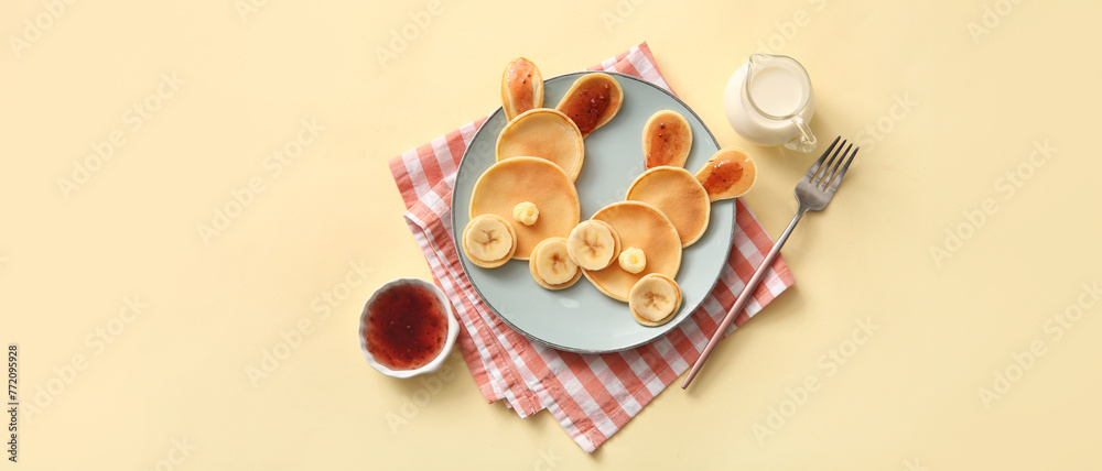 Funny Easter bunny pancakes with banana and jam on yellow background