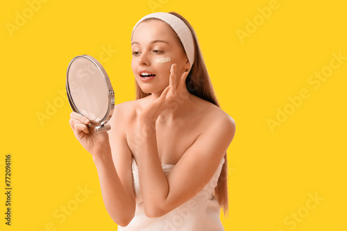 Young woman applying facial...