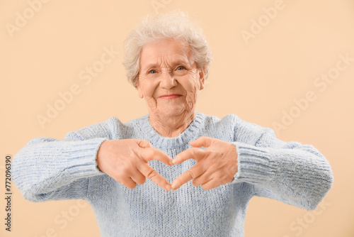 Senior woman making heart w...