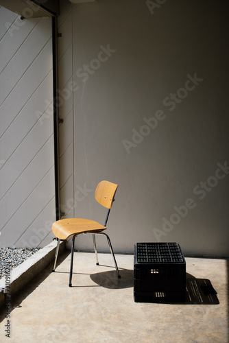 Wooden chairs and water crate bathed in sunlight.