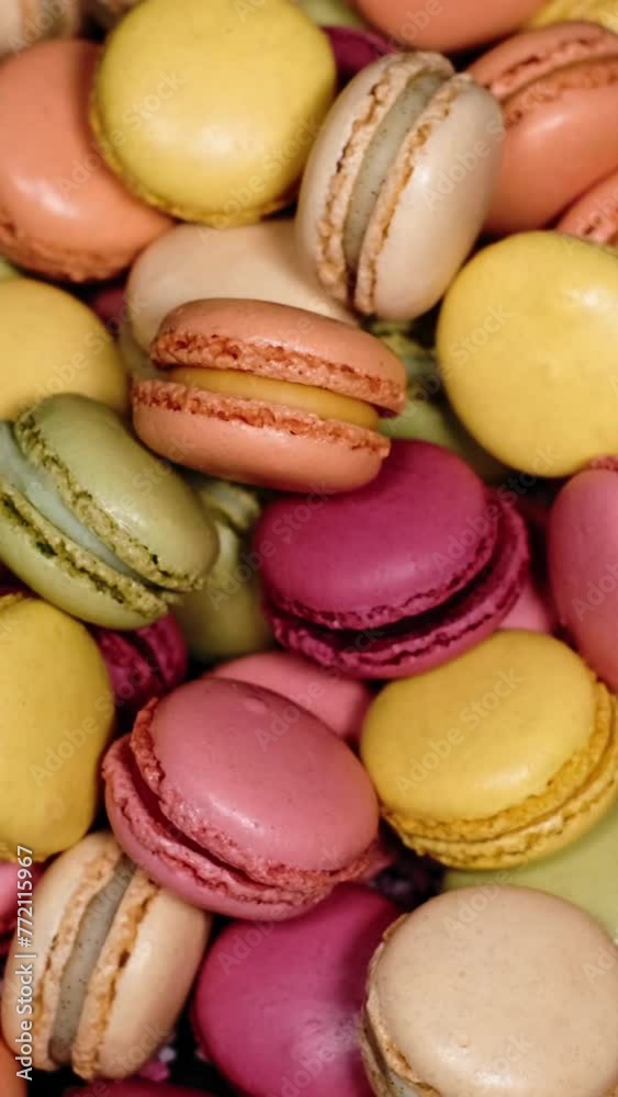 Top view of rotating fresh macaron cookies. Traditional french desserts from almond dough. Slow motion of colourful sweet macaron cakes spinning in a bakery shop. French cuisine or sweets concept. Top view of rotating fresh macaron cookies. Traditional french desserts from almond dough. Slow motion of colourful sweet macaron cakes spinning in a bakery shop. French cuisine or sweets concept.