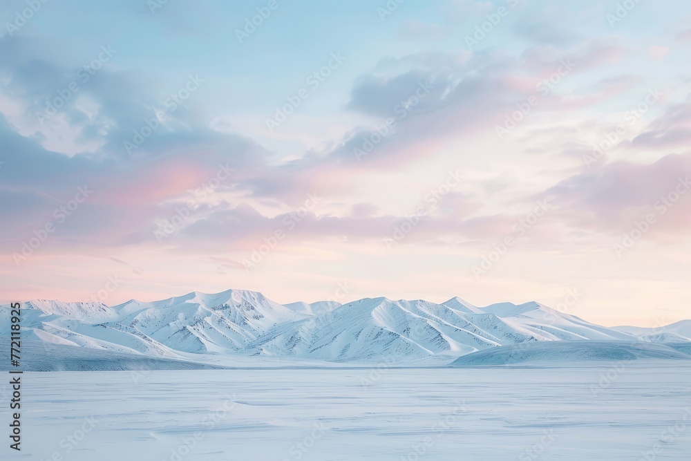 A wide-angle shot of a snow-covered landscape at dawn, with soft pastel hues in the sky and snow-capped mountains in the distance