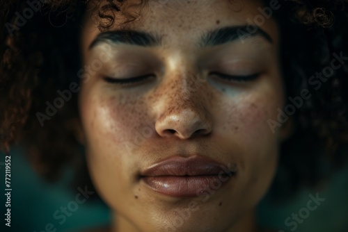 Close-up of a woman deeply meditating with her eyes closed, illuminated by soft natural light