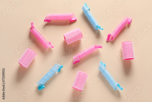 Different hair curlers on beige background