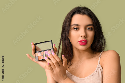Young woman holding eyeshad...
