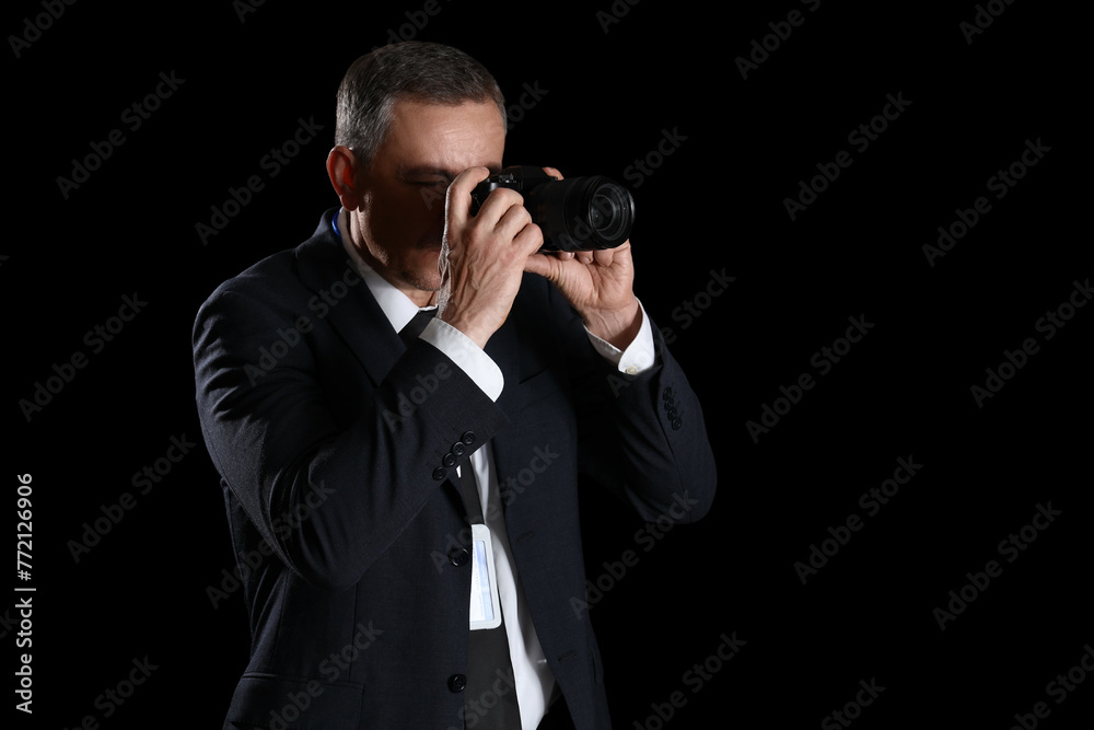 Mature FBI agent with photo camera on black background Mature FBI agent with photo camera on black background