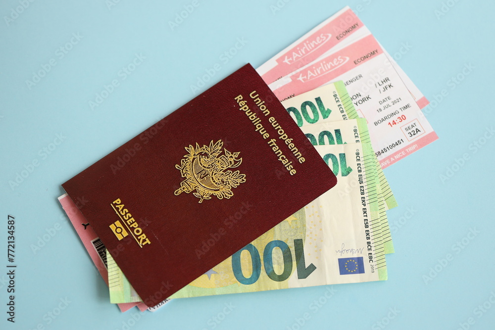 French passport and euro money with airline tickets on blue background close up. Tourism and travel concept French passport and euro money with airline tickets on blue background close up. Tourism and travel concept