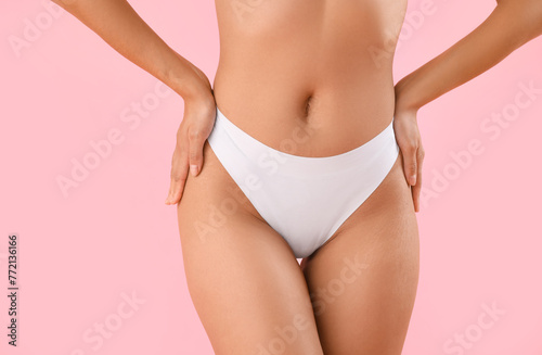 Beautiful young African-American woman with stretch marks on her body against pink background, closeup photo
