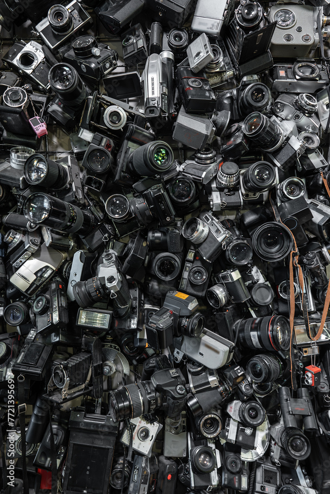 Fototapeta premium heap of old vintage film cameras and retro lenses, creative abstract photography and filmmaking background