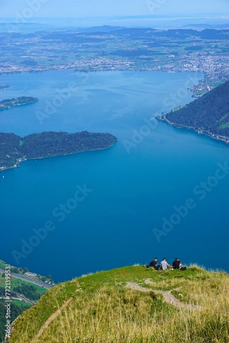 Hikers Resting on Mountaintop with Lake View photo