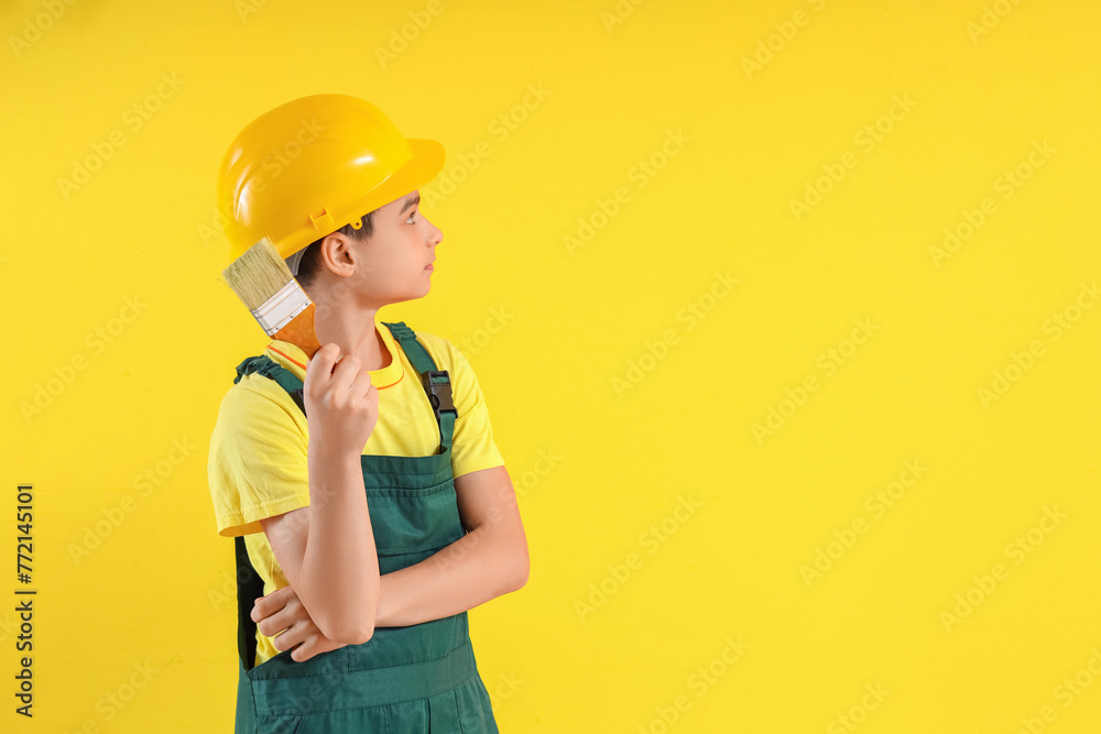 Little architect with paint brush on yellow background Little architect with paint brush on yellow background