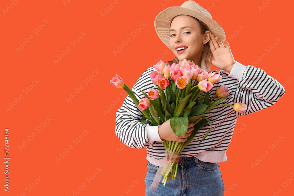 Young woman with hearing aid and tulips on orange background. International Women's Day - obrazy, fototapety, plakaty 